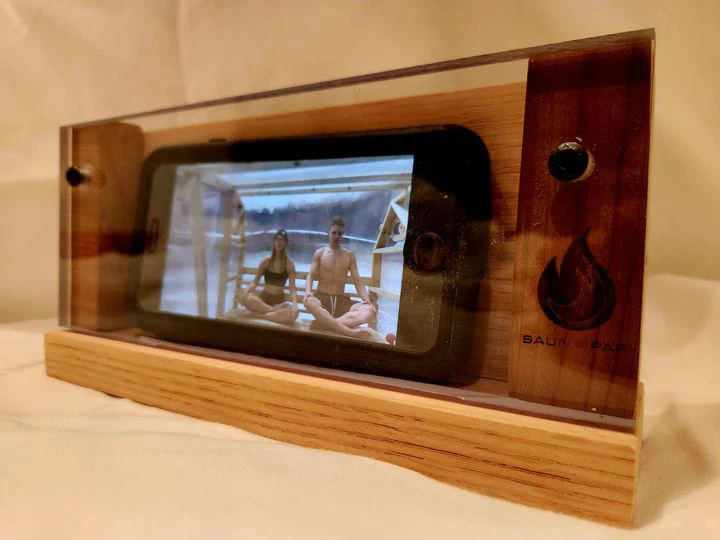 Product photo displaying a phone in the sauna phone case, featuring founders' breathing session