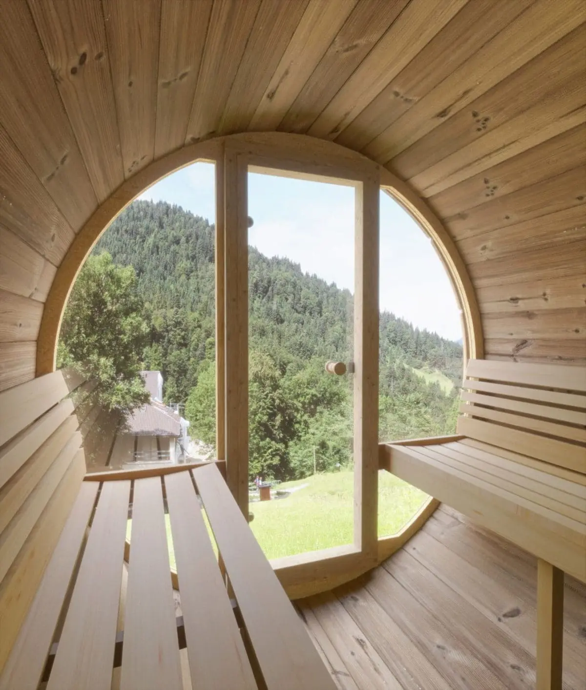 This Image Provides A View Of A Saunalife Barrel Sauna Set Within A Garden Setting. The Sauna'S Nordic Spruce Exterior Is Beautifully Contrasting With The Green Backdrop. The Barrel Design, Shingle Roof, And The Front Door Are Prominent, Inviting Viewers To Imagine A Relaxing Sauna Experience.