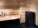 Harvia Virta standalone electric sauna heater in the corner of a modern sauna with light clear wood benches