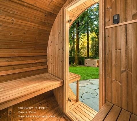Thermory classic sauna door with clear glass and nordic spruce installed in a thermory barrel sauna
